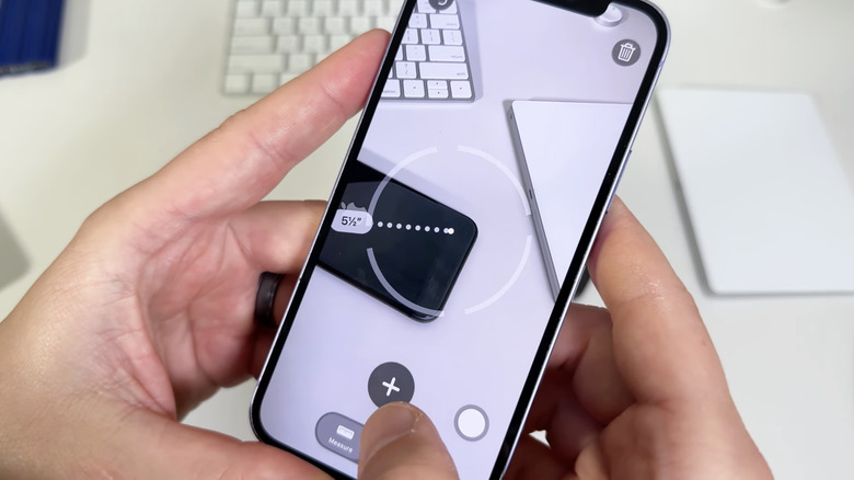 Мужчина использует измерительное приложение для iPhone