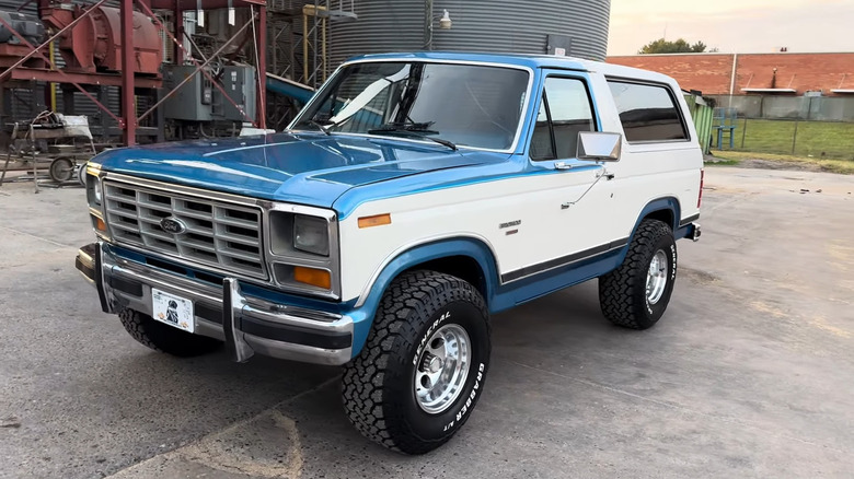 Вид сбоку бело-синего Ford Bronco 1982 года выпуска.