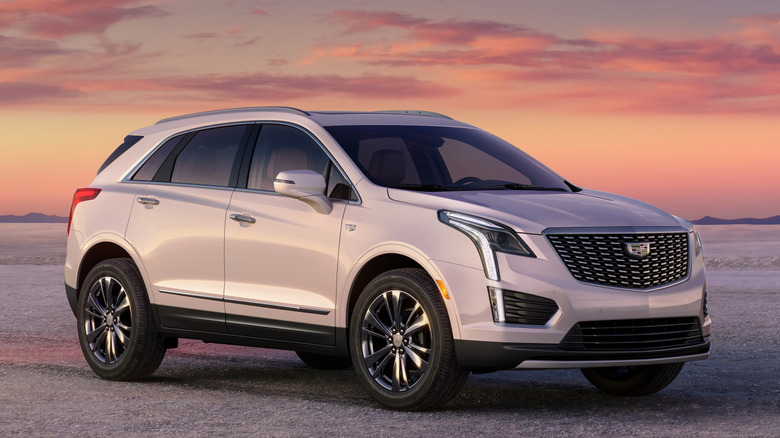 Вид спереди на 3/4 Cadillac XT5 2026 года на грунтовой дороге на закате