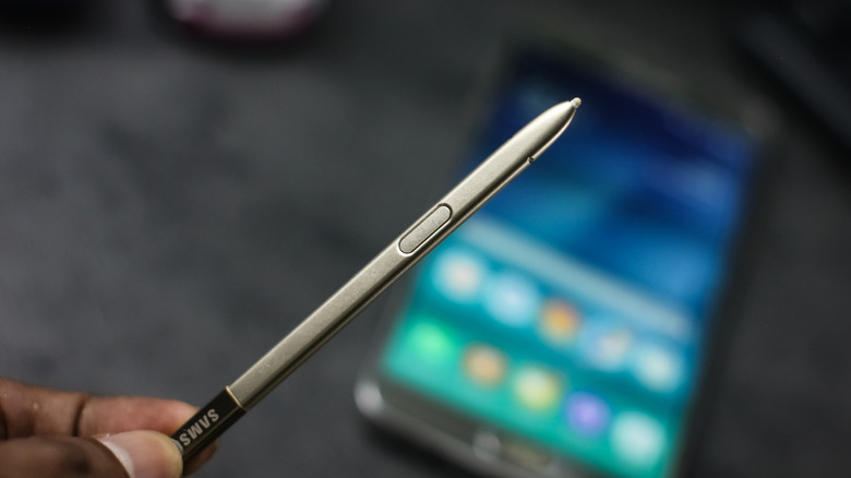 Samsung S Pen держится в пальцах.