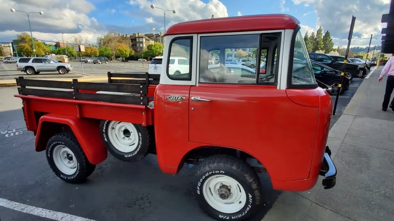 Красный Jeep Forward Control Series 1965 года, парковка на стоянке