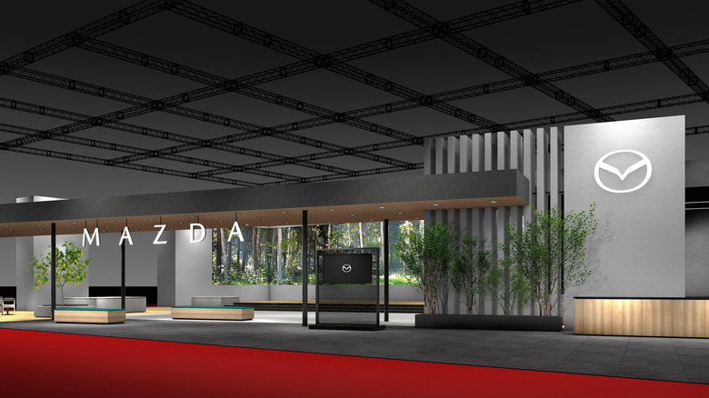Рендер Mazda на стенде Japan Mobility Show 2025 с новым логотипом и надписью.