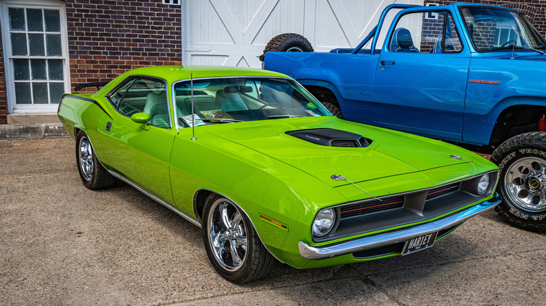 Plymouth Hemi 'Cuda 1970 года в цвете Sub-Lime Green припаркован перед домом.