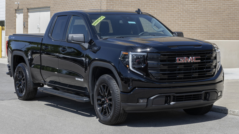 Черный GMC Sierra 1500 Elevation 3VL припаркован перед зданием