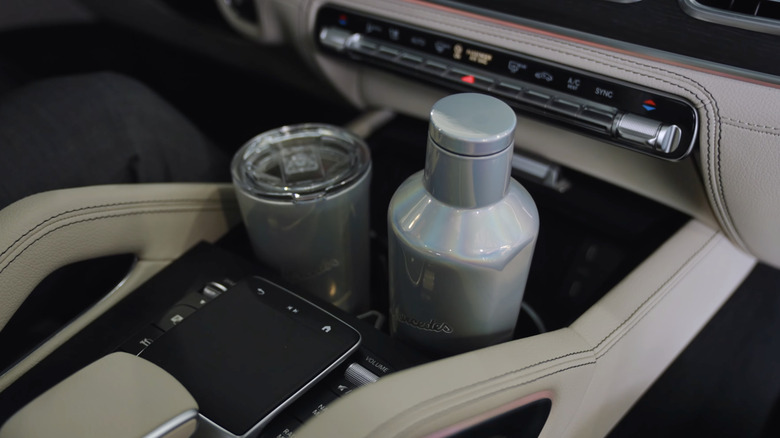 Крупный план центральной консоли Mercedes-Benz и двух подстаканников в использовании.