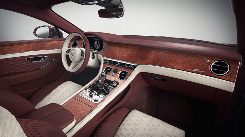 Вид изнутри роскошного двухцветного Bentley со скрытым дисплеем информационно-развлекательной системы.