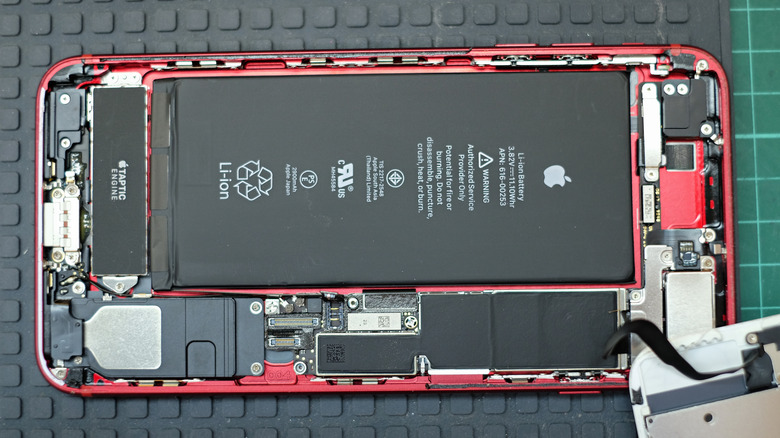 Разборка iPhone, демонстрирующая его внутренние части и аккумулятор
