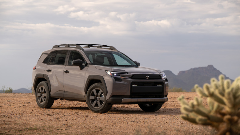 Toyota RAV4 Woodland 2026 года серого цвета в пустыне, вид спереди в 3/4
