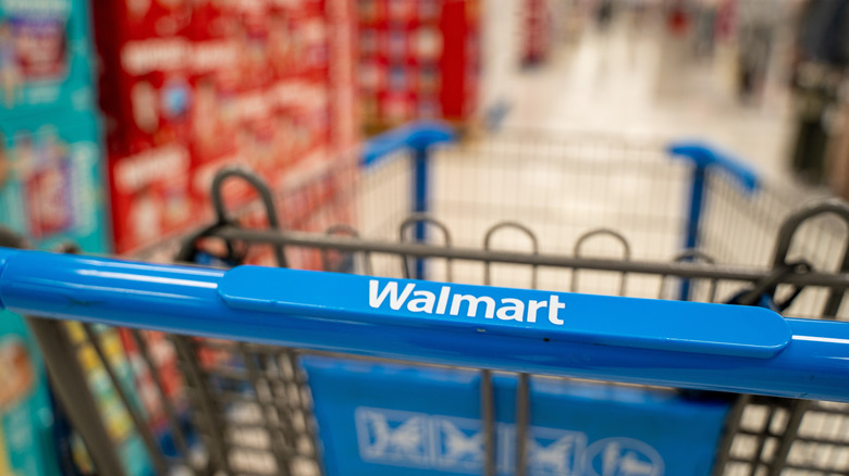 Тележку для покупок Walmart толкают по проходу.
