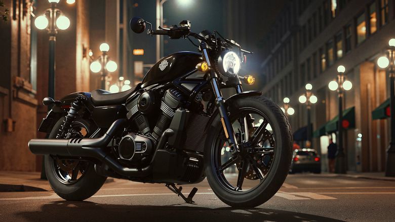 Черный мотоцикл Harley-Davidson Nightster припаркован на городской улице, освещенный уличным освещением.