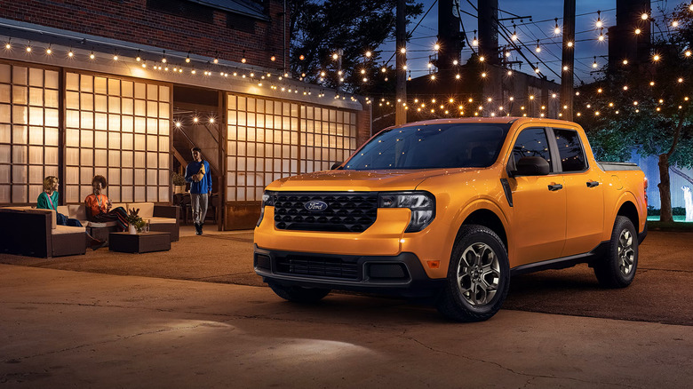 Оранжевый Ford Maverick 2026 года припаркован перед зданием ночью