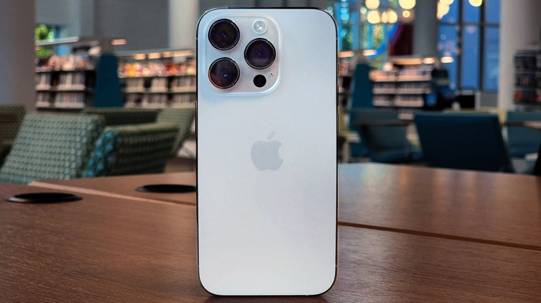 iPhone 14 Pro стоит вертикально на столе