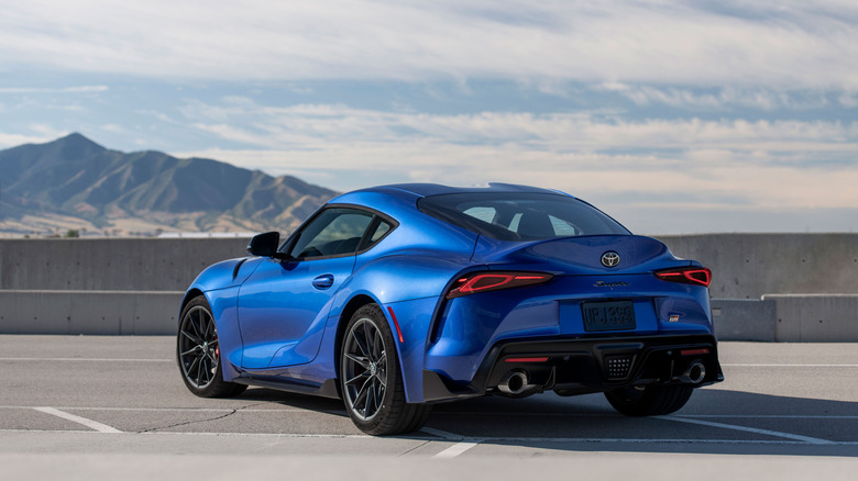 Toyota GR Supra 2026 года припаркована на стоянке, вид сзади слева в 3/4