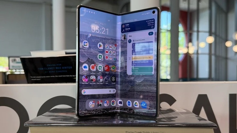 Motorola Razr Fold частично раскрыт и позирует на книге
