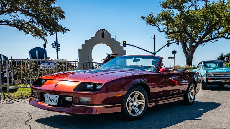 Человек за рулем Chevy Camaro IROC-Z на автосалоне