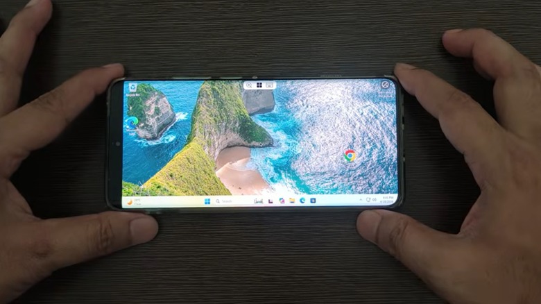 Человек с телефоном Android показывает рабочий стол Windows 11.