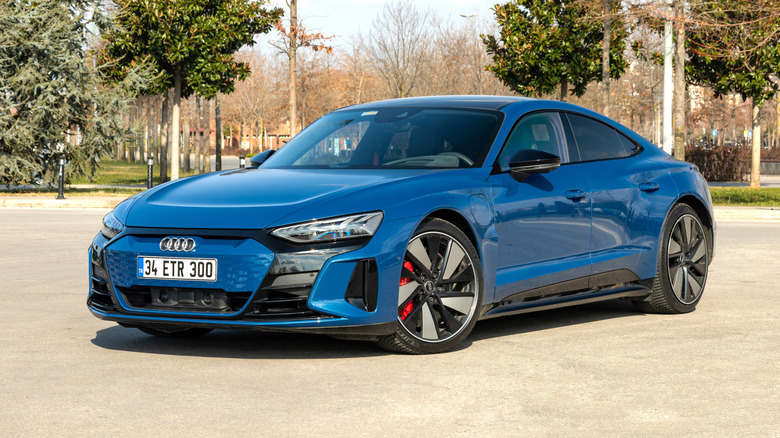 Синий роскошный электромобиль Audi e-tron GT припаркован снаружи.