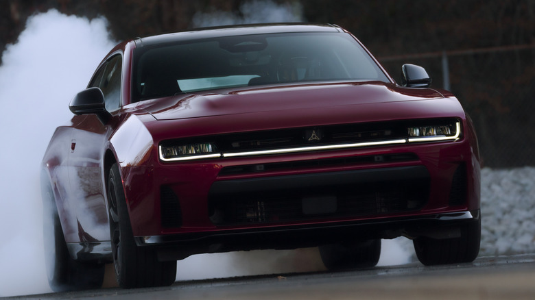 Вид спереди в 3/4 на двухдверный Dodge Charger, выгорающий на дрэг-стрипе