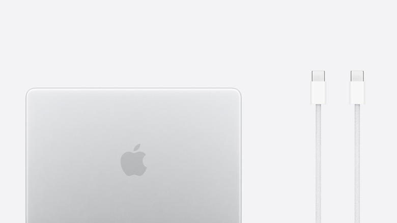 MacBook Neo рядом с прилагаемым кабелем для зарядки, белый фон