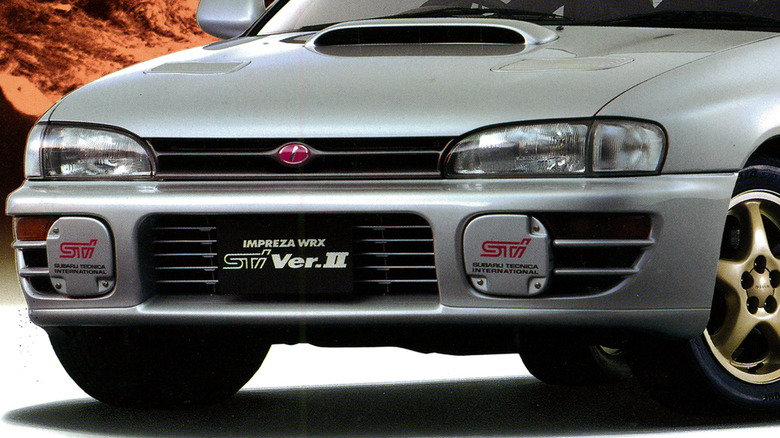 Крупный план решетки радиатора и переднего бампера Subaru WRX STI с розовым логотипом