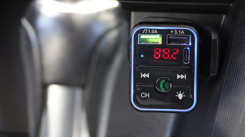 Автомобильное зарядное устройство Bluetooth FM внутри автомобильной вспомогательной розетки.