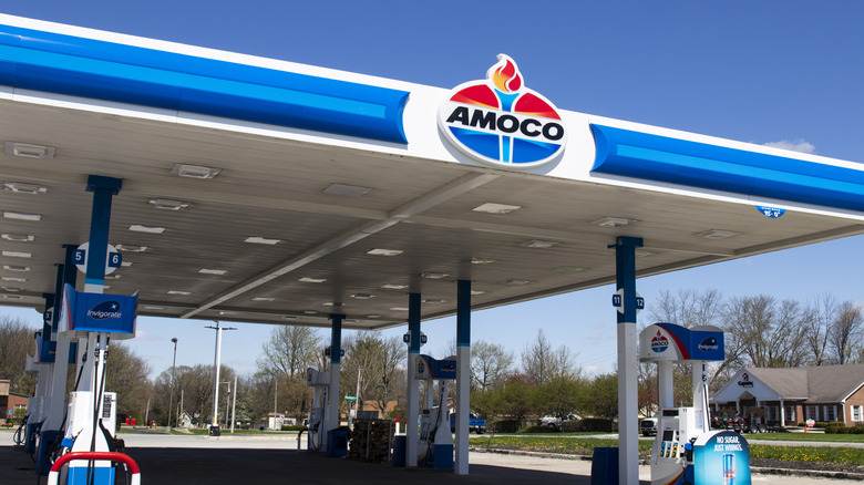 Заправочная станция Amoco с логотипом в виде факела над головой.