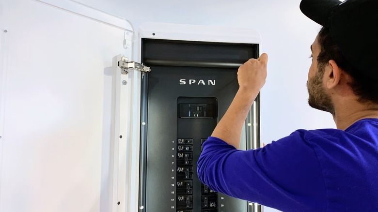 Техник SPAN работает над бытовой электрической панелью управления SPAN.