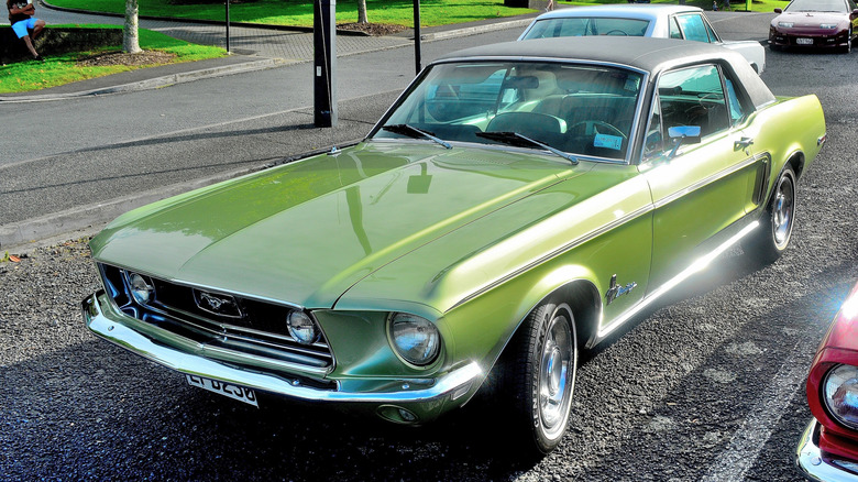 Зеленый Ford Mustang 1968 года, припаркованный на стоянке.