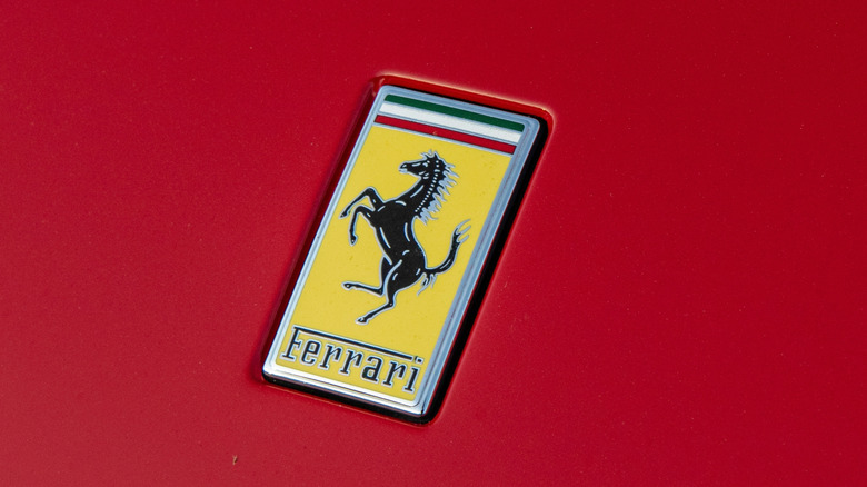 Текущий желтый логотип Ferrari на красном автомобиле.
