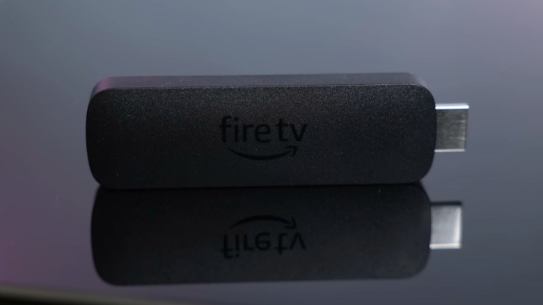 Amazon Fire TV Stick 4K Max на черной отражающей поверхности