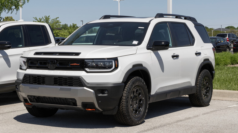 Передние 3/4 белого внедорожника Honda Passport, припаркованного на автосалоне.