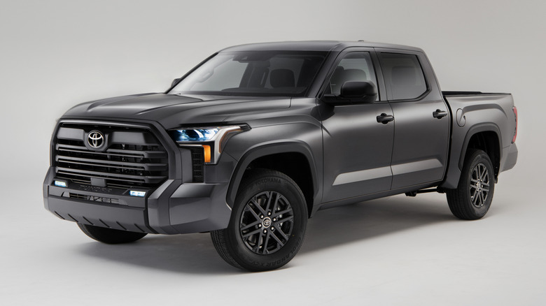 Вид спереди на 3/4 серого пикапа Toyota Tundra, припаркованного в студии.