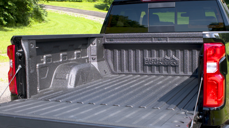 Вид снаружи на заводскую обшивку кузова черного пикапа Chevy Silverado High Country 2019 года выпуска.