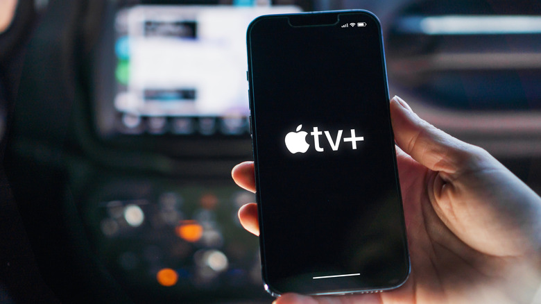 Человек, использующий Apple TV на iPhone в машине