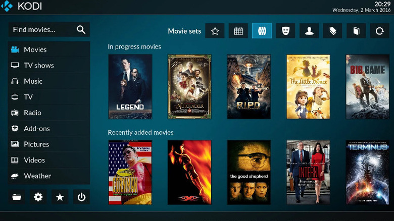 Домашняя страница Kodi, множество постеров фильмов в центре.