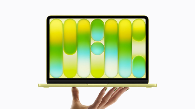 Рука держит MacBook Neo