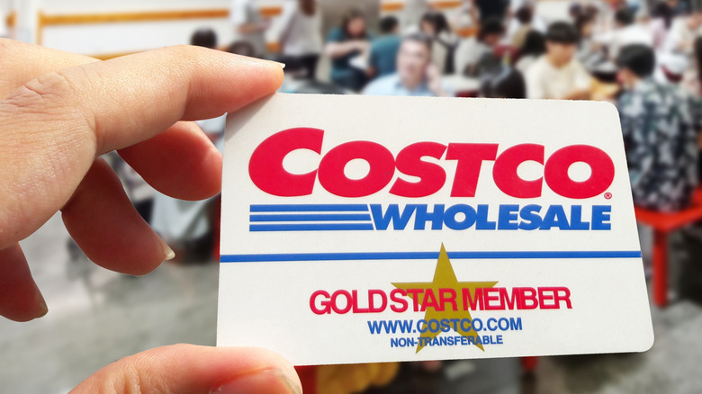 Крупный план руки, держащей членскую карту Costco Gold Star в магазине Costco.