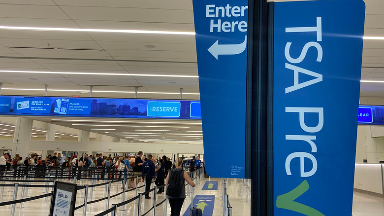 Путешественник проходит через линию досмотра TSA Pre Check в терминале C в международном аэропорту Орландо.