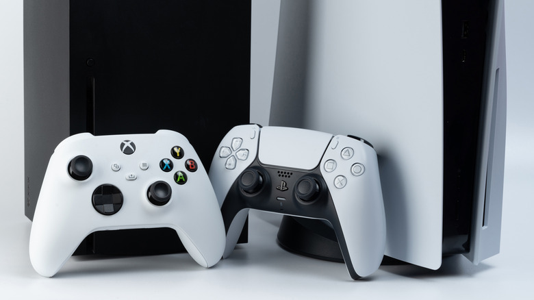 Крупный план Xbox Series X и PlayStation 5 с контроллерами между ними.