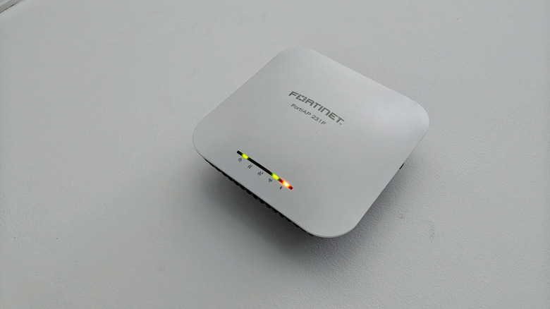 Точка беспроводного доступа Fortinet на серой поверхности