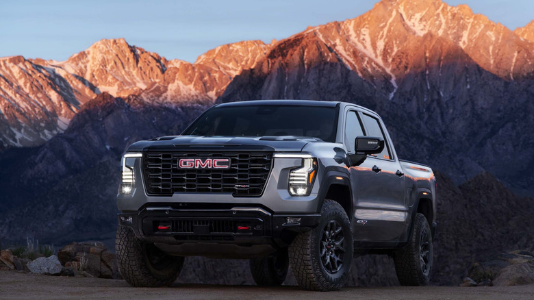 GMC Sierra AT4X 2027 года припаркован на рассвете на фоне гор