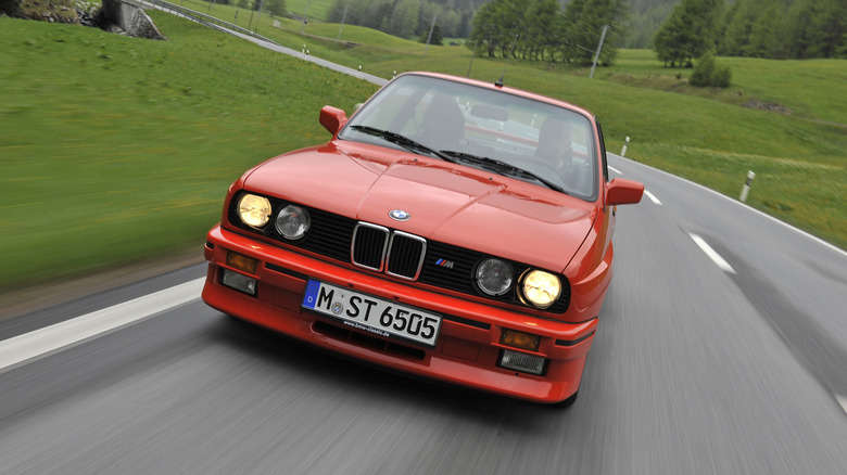 BMW E30 M3 едет по европейской проселочной дороге, вид спереди