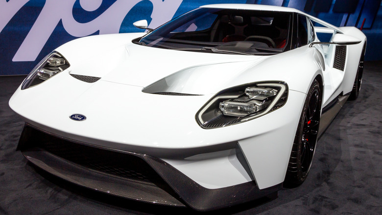 Вид спереди на 3/4 белого Ford GT, выставленного на стенде автосалона.