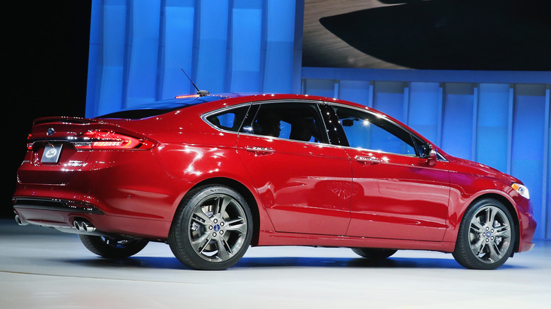 Вид сзади в 3/4 на красный Ford Fusion Sport, представленный на автосалоне.