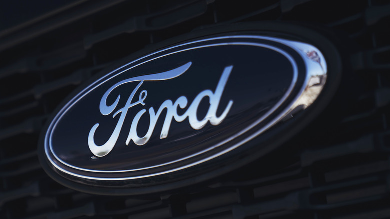 Крупный план эмблемы Ford на решетке автомобиля.