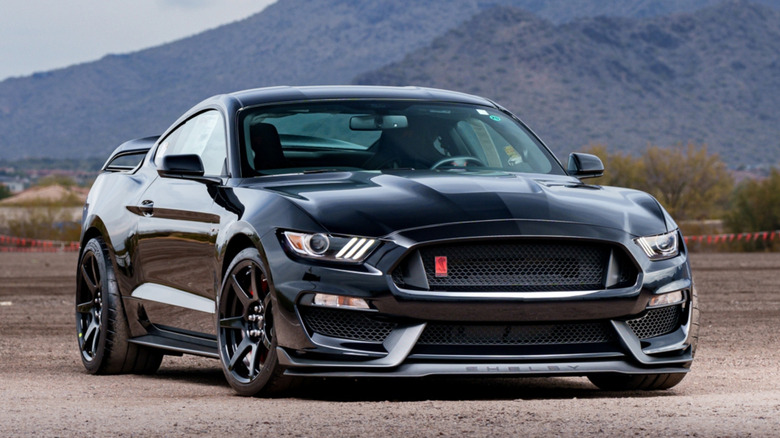 Вид спереди черного Ford Mustang Shelby GT350R 2017 года, припаркованного в пустыне.