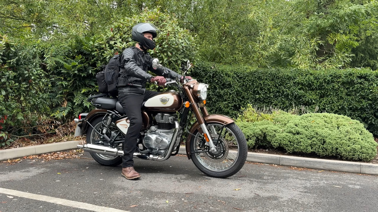 Человек на Royal Enfield Classic 350 собирается выехать с места для парковки
