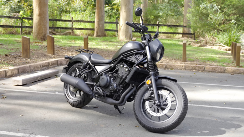 Черный Honda Rebel 500 на стоянке с поднятой подножкой, вид спереди на 3/4