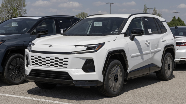 Белая Toyota RAV4 2026 года выпуска на стоянке автосалона.
