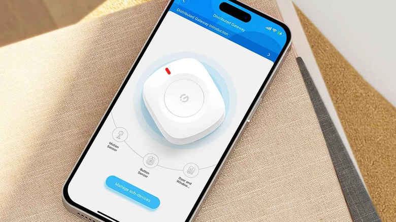 GoveeLife Wireless Mini Smart Button Sensor лежит на телефоне.